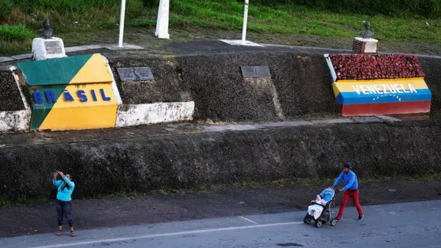 Famílias caminhamharam slotestradaharam slotcujas margens estão duas pinturas com dizeres e cores respectivasharam slotcada país: Brasil e Venezuela