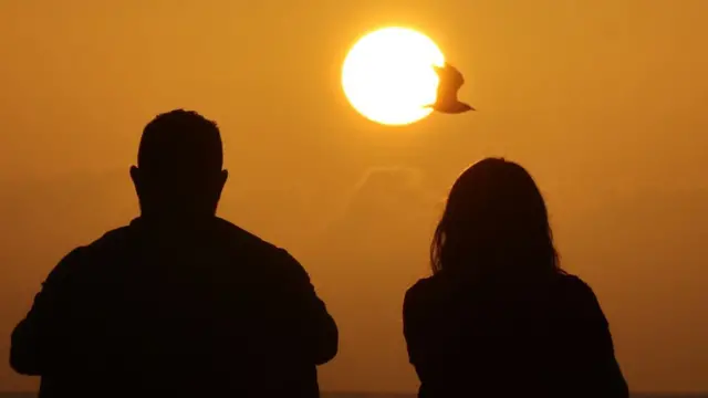 Una pareja frente al sol