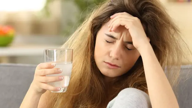 Chica joven con resaca.