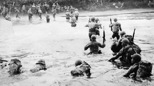 American soldiers going ashore through swirling waters at Toem, on the coast of Dutch New Guinea
