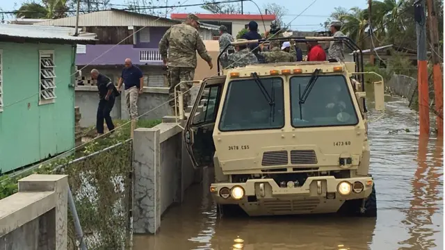 Convoy del ejército sobre calles inundadas.