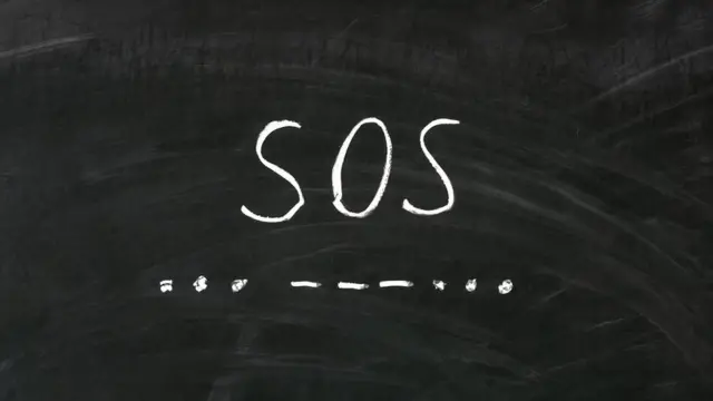 A blackboard with the letters SOS and the SOS message written in Morse code