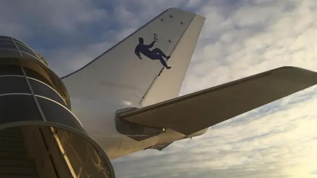 يُظهر ذيل الطائرة رسما لشخص يطفو في الفضاء