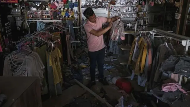 ગાઝામાં પોતાની દુકાન વ્યવસ્થિત કરતા એક દુકાનદાર