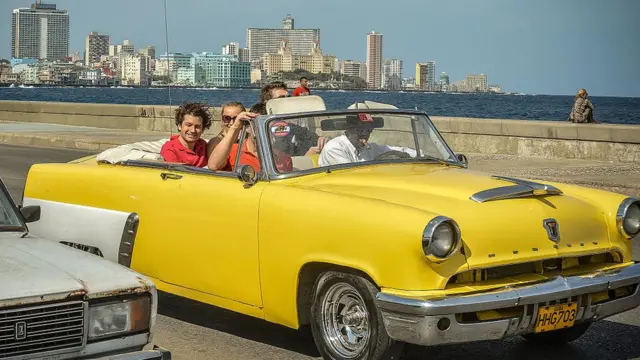 Turistas paseando en un auto antiguo en La Habana.