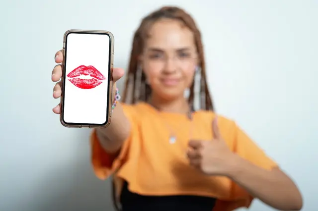 Fille tenant un téléphone avec un baiser