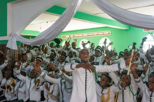 Mutane sanye da tufafi iri daya sun a maci tare da rera waka a majami'ar Kimbanguist a Jamhuriyar Dimukradiyyar Congo.