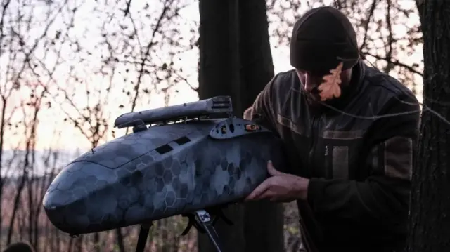 A pilot from the Predator Brigade's unmanned vehicle unit of the Ukrainian Patrol Police in Donetsk assembles a GARA bomber drone on a night-time strike mission against Russian forces on the Pokrovsk front line, Ukraine, in  November 2025.