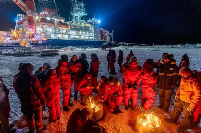 నిప్పు వెలిగించి దాని చుట్టూ చేరిన పరిశోధకులు