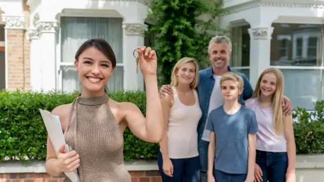 Una chica enseña la llave de su nueva casa