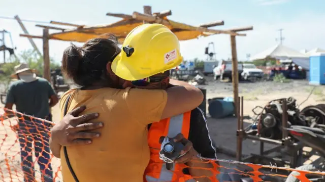 Sergio Martínez Valdés, hermano de uno de los mineros, se abraza con su esposa.