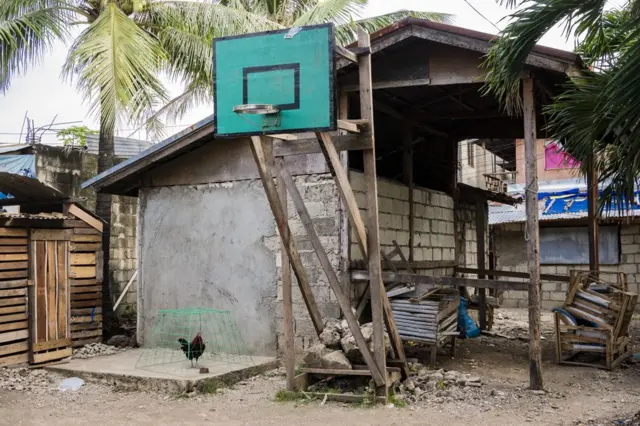 شبكة كرة سلة ولوحتها الخلفية في فناء خلفي لأحد المنازل