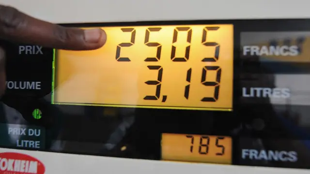 Un client pointe du doigt le tableau de la station d'essence