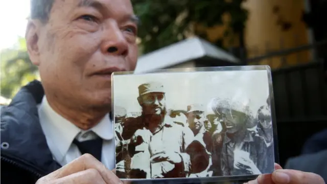 Ông Cao Khắc Thuận, từng học tập tại Cuba, cầm bức ảnh ông chụp chung với Chủ tịch Fidel Castro năm 1967