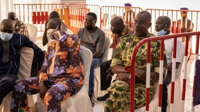 Le général burkinabé Gilbert Diendere (en uniforme) et d'autres accusés assistent à l'ouverture du procès des auteurs présumés de l'assassinat de Thomas Sankara à Ouagadougou, le 11 octobre 2021