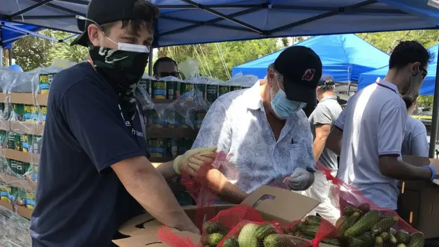 Un grupo de voluntarios preparan cajas de alimentos para donar