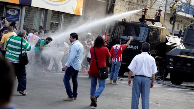 Un vehículo de la policía lanzando chorros de agua contra los manifestantes.