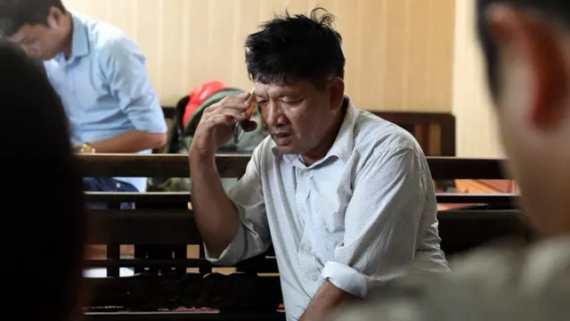 Cha của Đoàn Thị Hương nói chuyện trên điện thoại khi đang theo dõi phiên tòa diễn ra hôm nay tại nhà ở Nam Định.