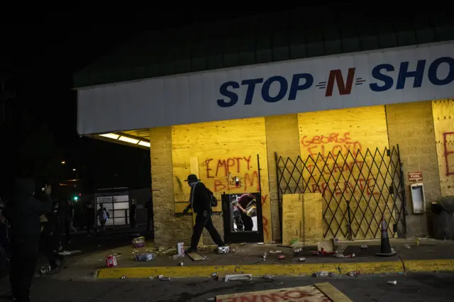 14. Looters steal goods from a gas station during unrest resulting from the killing of an unarmed black man, George Floyd, by police