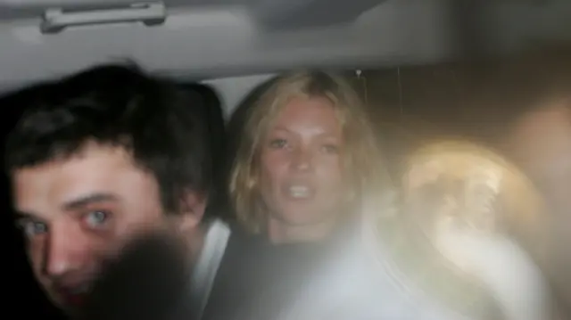 Kate Moss in a car with Pete Doherty throwing a full beer can at photographers at the first day of the Glastonbury Music Festival 2005 at Worthy Farm, Pilton on June 24, 2005