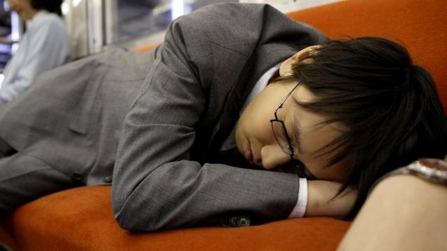 Спящий одетым на работе японец