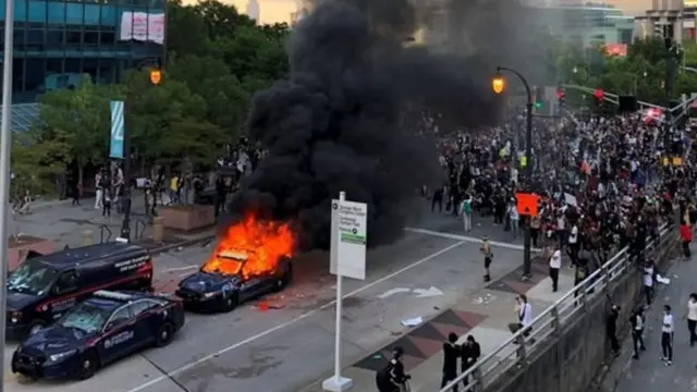 Gari la polisi likichomwa moto na waandamanaji waliokuwa wamekusanyika karibu na ofisi za shirika la utangazaji wa CNN Atlanta, Georgia