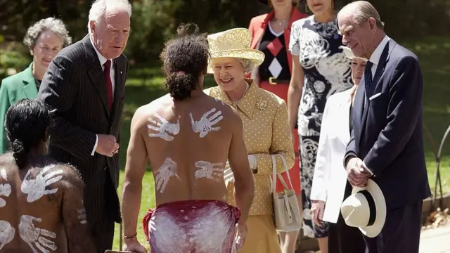 الملكة إليزابيث الثانية و زوجها الأمير فيليب دوق أدنبره وممثلهم الحاكم العام في أستراليا بيتر هولينغوورث يلتقون بالراقصين من الأستراليين الأصليين خلال مراسم احتفالية بمناسبة بدء الزيارة الملكية إلى أستراليا ، 27 فبراير/شباط 2002 في أديلايد.