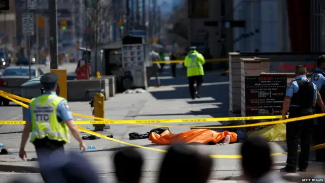 A tarp lays on top of a body on Yonge St. at Finch Ave. after a van plowed into pedestrians on April 23, 2018 in Toronto, Canada.