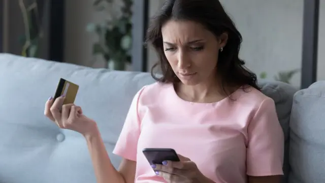 Una mujer revisa en su móvil las transacciones sospechosas de su tarjeta de crédito