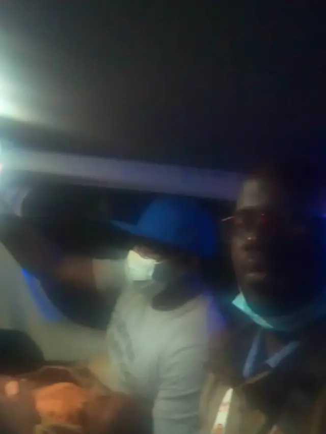 Le Dr Yonta transportant le bébé dans l'ambulance