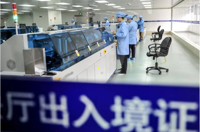 图为广东公安厅出入境证件控制中心内,工作人员在制作护照(资料照片)。