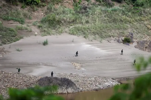 Ethnic minority Karen troops approach a Myanmar army outpost near the Thai border, as seen from the Thai side on the Thanlwin, also known as Salween, riverbank in Mae Hong Son province, Thailand, April 28, 2021