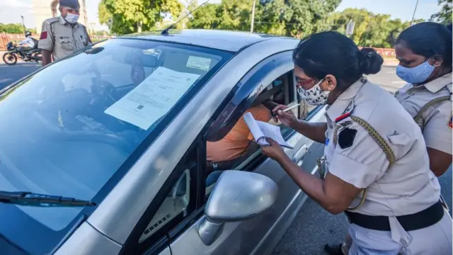 Police women for India dey write fine for man inside car wey no wear face mask