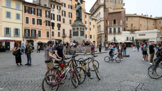 Cyclists stop in the Camp di Fiori square in central Rome, Italy. Photo: 16 May 2020