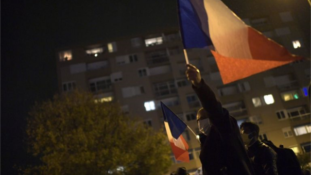 Homembonus cadastromáscara ergue bandeira da Françabonus cadastromanifestação à noite