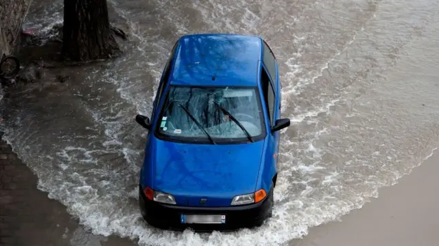 Автомобиль едет по затопленной улице
