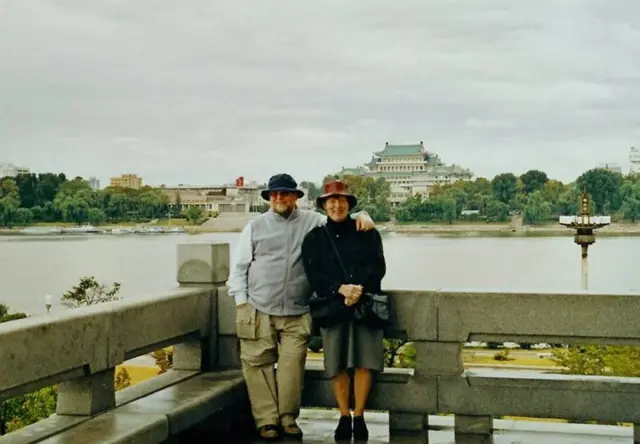2001년 제임스 호어 대리대사가 아내인 수잔 여사와 대동강에서 포즈를 취하고 있다. 강 너머 북한 중앙 도서관이 보인다