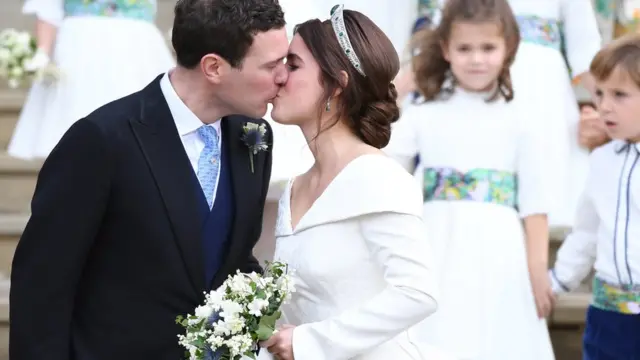 Britain"s Princess Eugenie (R) and her husband Jack Brooksbank kiss as they exit St George"s Chapel