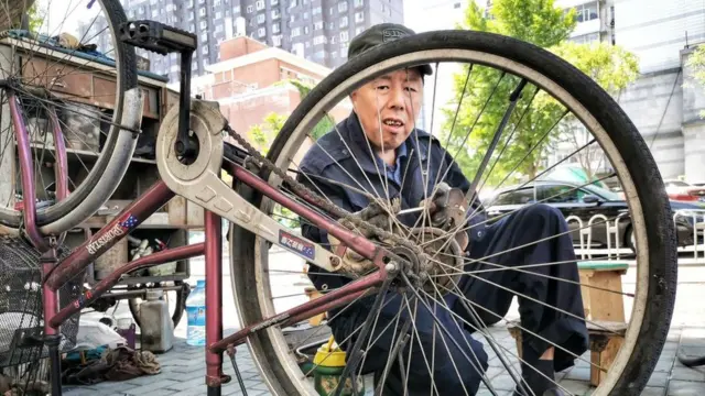 বেইজিং-এ এক ব্যক্তি তার সাইকেল মেরামত করছেন, ১১-০৫-২০২০।