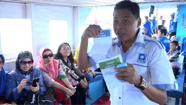 Awi menjelaskan lima jenis surat suara yang bisa dicoblos saat pemilu nanti kepada pendukungnya, saat berada di atas kapal dalam perjalanan dari Tuminting ke Bunaken Kepulauan (22/3)