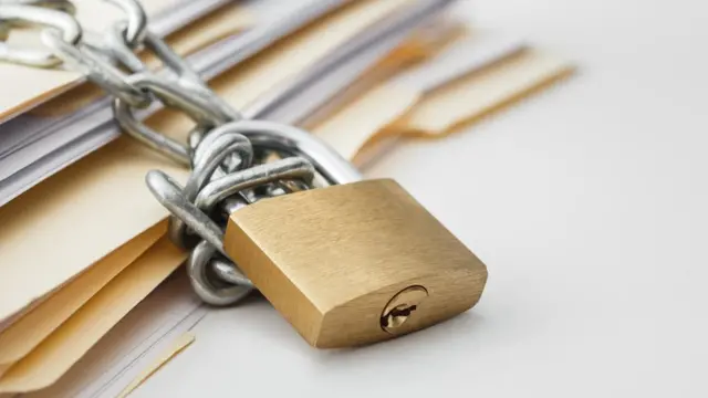 Un candado guarda unos documentos.