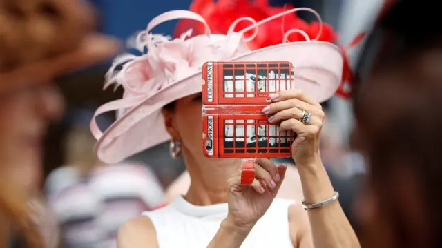 женщина в розовой шляпке делает селфи