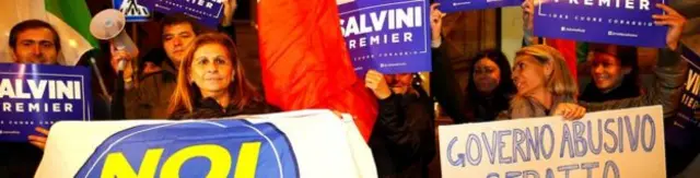 ชาวอิตาเลียนยืนถือป้าย