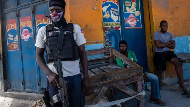 Un policier haïtien tenant une arme