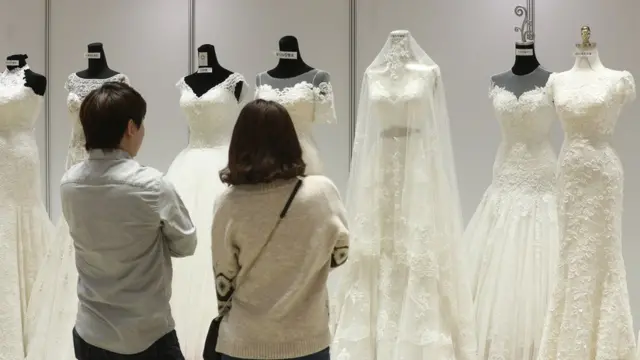 지난 10월 21일 서울 강남구 코엑스에서 열린 웨덱스 웨딩박람회에서 예비 신혼부부들이 드레스를 살펴보고 있다