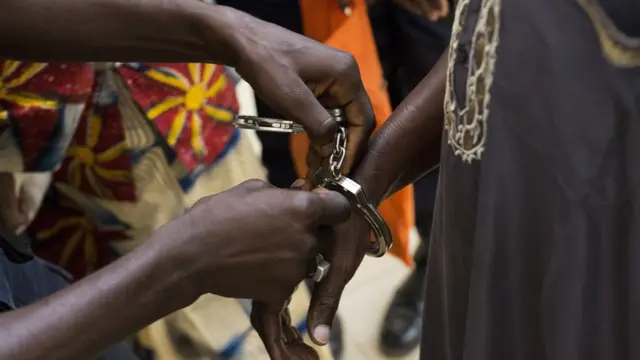 Police remove the handcuffs from political prisoners arriving for their hearing at Gambia"s supreme court in Banjul, Monday, Dec. 5, 2016. They had been arrested in April 2016 after they took part in a peaceful demonstration and sentenced to three years in prison. The appeals court ordered their release on bail, just days after strongman ruler Yahya Jammeh agreed to step aside after losing the presidential election to Adama Barrow