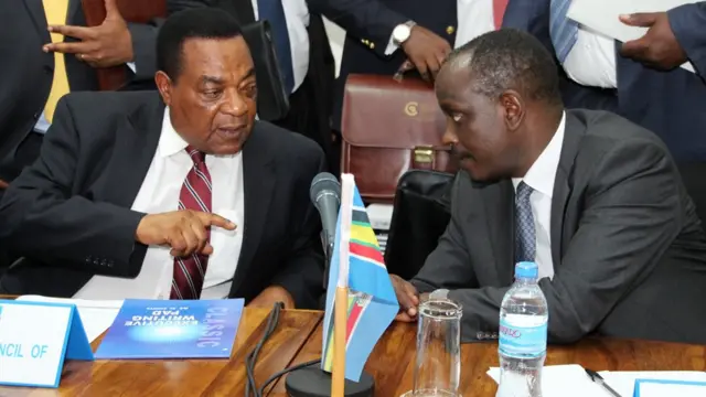 Waziri wa mambo ya nje wa Tanzania Augustine Mahiga akinong'onezana na Dkt Richard Sezibera wakati wa mazungumzo kuhusu mzozo wa kisiasa nchini Burundi yaliyokuwa yanafanyika mjini Arusha, Tanzania Januari 6 mwaka 2016