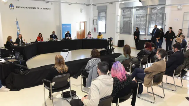 Acto de perdón con personas sentadas alrededor de una mesa en Argentina.