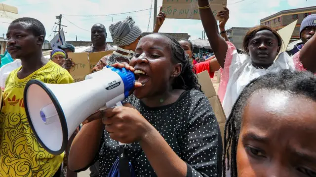 Residents and activists of Mathare slum hold placards and shout slogans during a protest