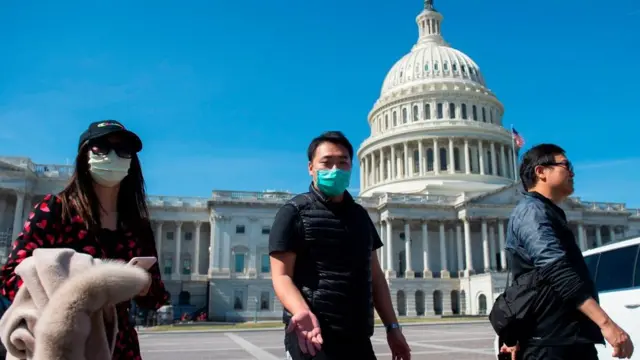 A tour operator, wearing a protective mask, gestures as he leads a tour near the US Capitol in Washington, DC on 9 March, 2020